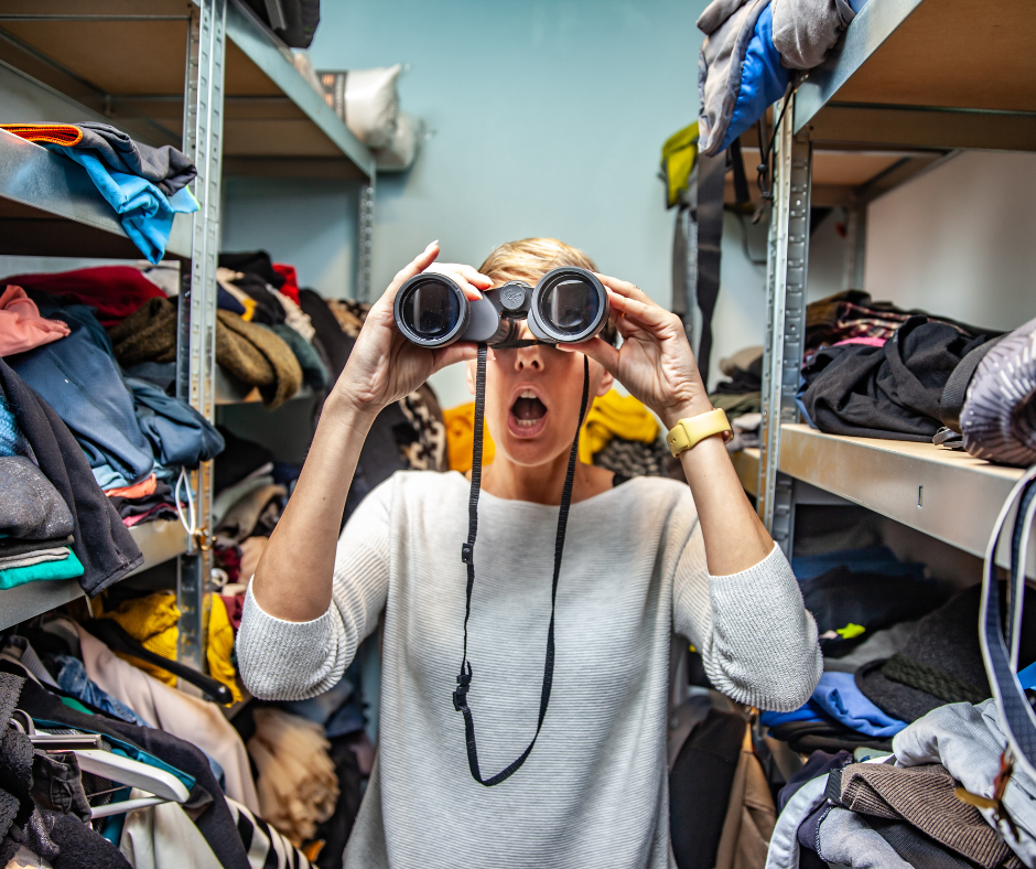 woman with binoculars in cluttered closet